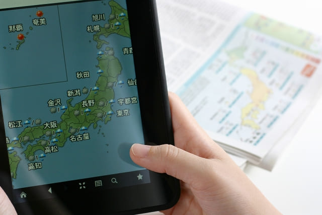 タブレットで天気予報をチェックしている右手